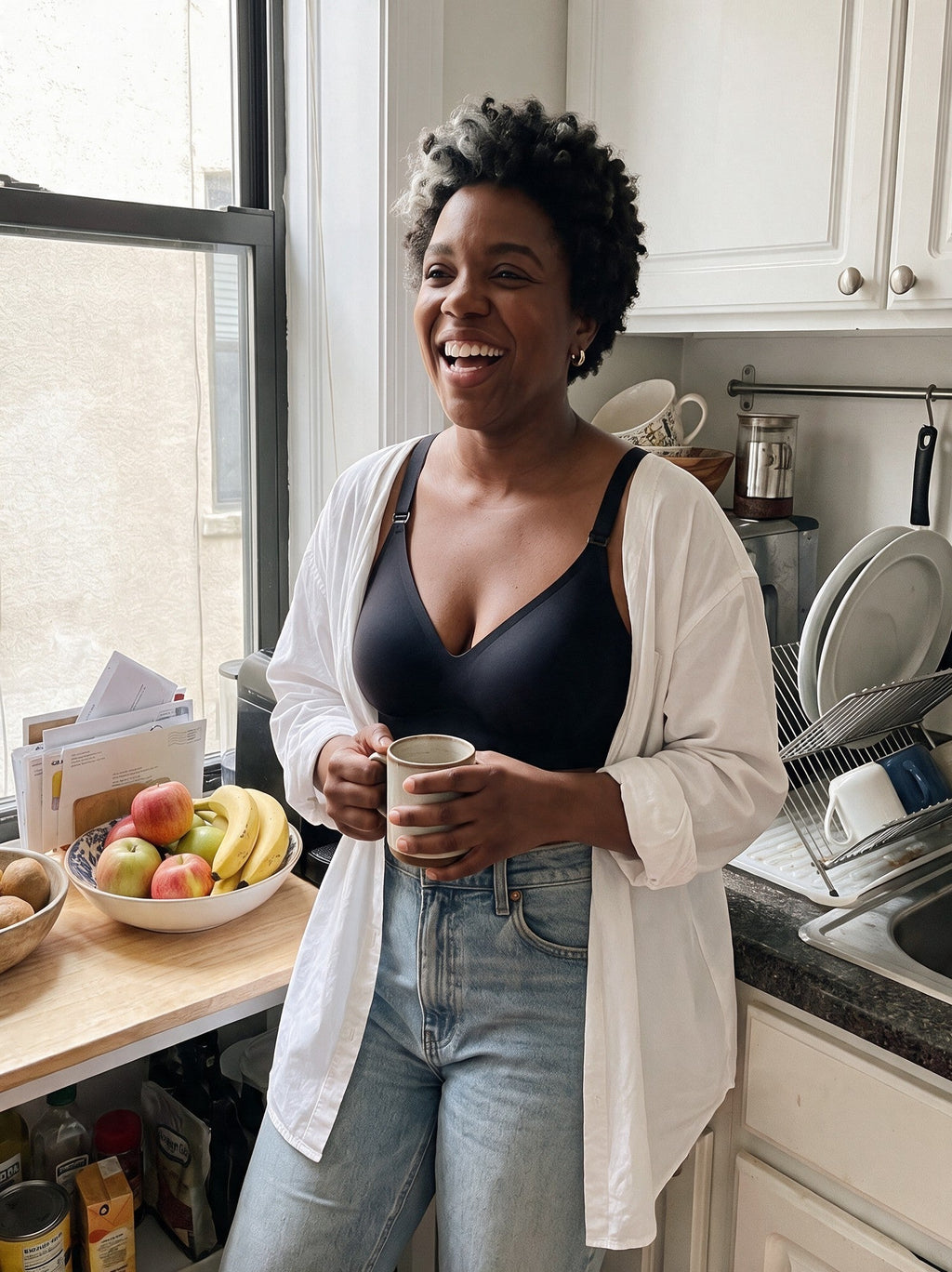 [Encre] Femme qui rit dans sa cuisine, soutien-gorge Nidélie noir sous une chemise blanche