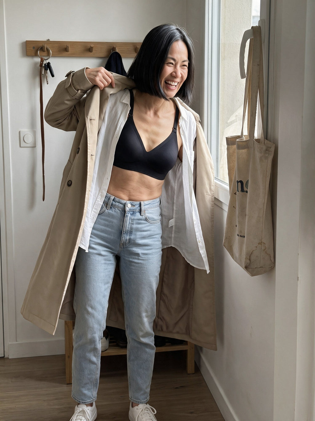 [Encre] Femme qui enfile son trench dans l'entrée, soutien-gorge Nidélie Encre